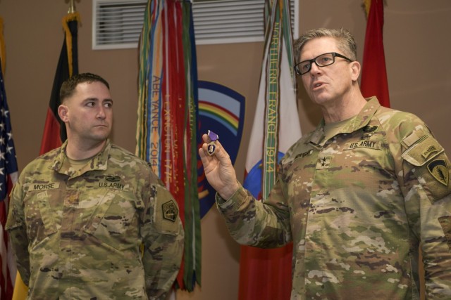 U.S. Army Maj. Gen. Peter Andrysiak, deputy commanding general for U.S. Army Europe and Africa holds a Purple Heart award, that was later presented to Maj. Robert Morse, chief of theatre operations for Regional Cyber Center-Europe, U.S. Army Cyber...