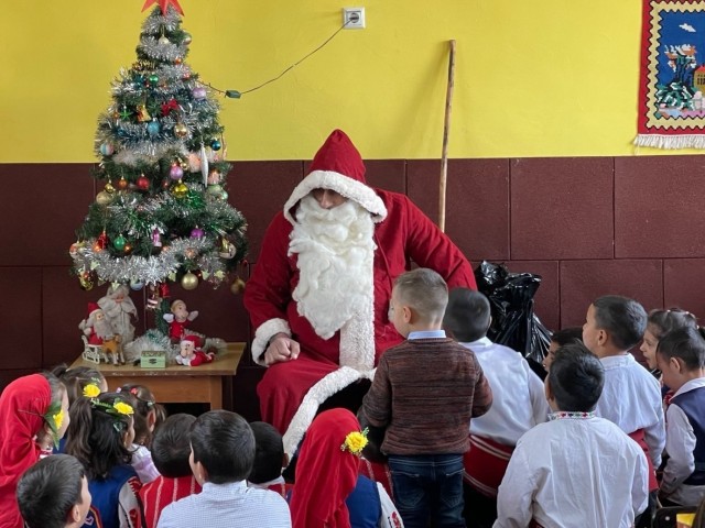 Santa asks the children how they behaved throughout the year before giving them gifts, December 22, 2021. Novo Selo Training Area personnel were invited to local schools to share and exchange holiday traditions, and learn about local culture.  