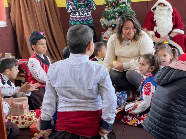 Irish Demaree, a human resources specialist at Novo Selo Training Area, Bulgaria, speaks with school children in a local village, December 22, 2021. Novo Selo Training Area personnel were invited to local schools to share and exchange holiday traditions, and learn about local culture. 