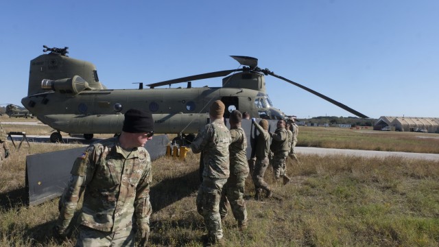 U.S. Army Spc. Drew Gillaspie, a CH-47 helicopter repairer with Delta Company, 7-158th General Support Aviation Battalion, 11th Expeditionary Combat Aviation Brigade, leads a group of Soldiers as they carry part of a CH-47 Chinook helicopter at...