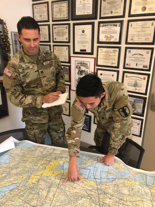 Capt. Robert D. Meland and Spc. Claude S. Sanders both from the 303rd Maneuver Enhancement Brigade (MEB) discuss enemy obstacles and indirect fire tactics encountered by 303rd MEB convoys during the simulated scenario of Exercise Yama Sakura 81 at...