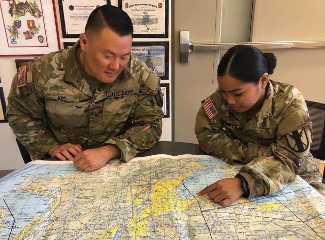 Maj. Christopher Kim and Spc. Maria Benaza from the 303rd Maneuver Enhancement Brigade (MEB) discuss the potential location of a Forward Logistics Element (FLE) during the simulated scenario of Exercise Yama Sakura at Schofield Barracks, HI...