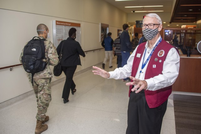 John Scanlon greets staff members as they arrive at Brooke Army Medical Center, Fort Sam Houston, Texas, Nov. 18, 2021. Scanlon, an Air Force retiree, has been volunteering at BAMC since 2017. (U.S. Army photo by Jason W. Edwards)
