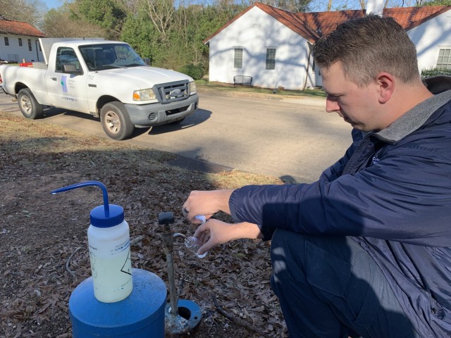 Chris Hill, Columbus Water Works lead water technician, collects a water sample at a sampling station on Fort Benning, Jan. 5, 2022.