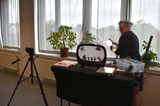 Supervisory librarian sets up shadow puppets