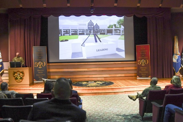 Attendees to the  NCOLCoE 50th anniversary watch a presentation on the history of the organization. 