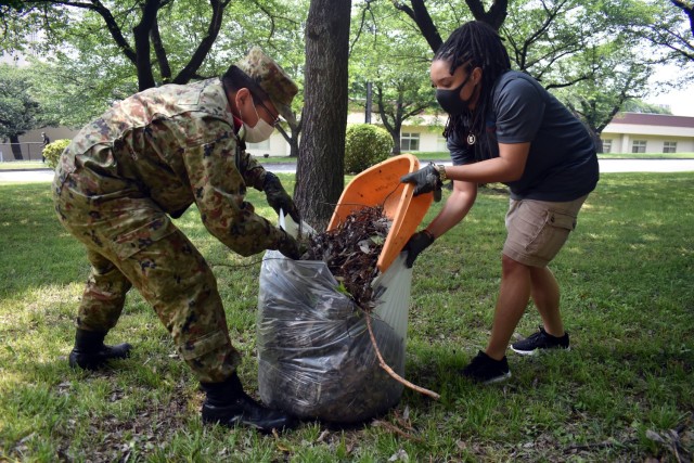 Sgt. Jennifer Jackson, right, president of Camp Zama’s Better Opportunities for Single Soldiers program, and 1st Lt. Naoki Kumagai, assigned to the 4th Engineer Group, Japanese Ground Self-Defense Force, work together to clean up the area around the Otakebi torii during a BOSS community outreach event at Camp Zama, Japan, May 27, 2020.