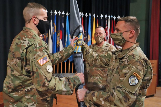 Command Sgt. Maj. Kevin Flickinger (left) receives the colors of the Army Cyber Protection Brigade (CPB) from brigade commander Col. John Popiak in a change of responsiblity ceremony at Fort Gordon, Ga., Feb. 3, 2022. Flickinger's acceptance of...