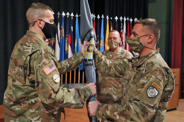 Command Sgt. Maj. Kevin Flickinger (left) receives the colors of the Army Cyber Protection Brigade (CPB) from brigade commander Col. John Popiak in a change of responsiblity ceremony at Fort Gordon, Ga., Feb. 3, 2022. Flickinger's acceptance of the colors signified his assumption of the brigde senior enlisted leader position. Flickinger succeeds Command Sgt. Maj. Jesse Potter (center), who served with the CPB since 2019. (Photo by Staff Sgt. Roman Rajm)