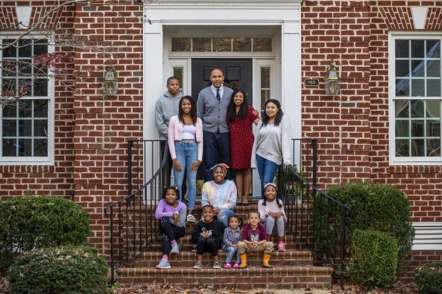 Benjamin Spencer, dean of the William & Mary Law School and a U.S. Army Reserve captain, and his wife, Marlette, pose for a family portrait with their nine children in front of their home in Williamsburg, Virginia, Dec. 3, 2020. Spencer is the first African-American dean hired by the oldest law school in the country and a U.S. Army Reserve officer and lawyer who works for the Government Appellate Division. Spencer graduated from Harvard Law School and joined the Army when he was almost 41 because he felt a calling to serve people and serve his nation. (U.S. Army Reserve photo by Master Sgt. Michel Sauret)