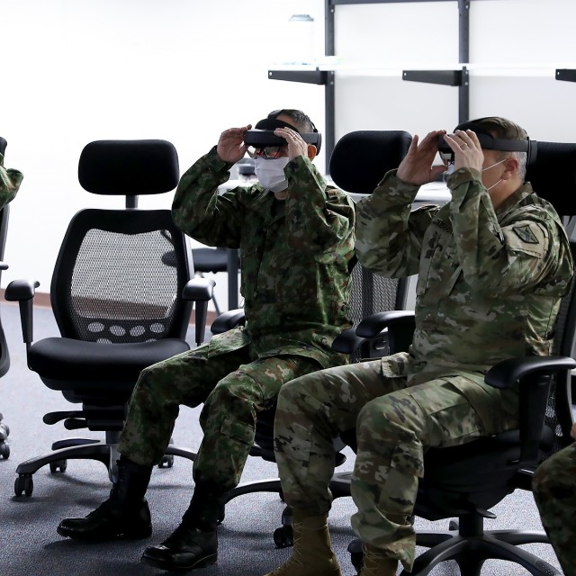 Maj. Gen. Shinichi Aoki, Japanese Ground Self Defense Force and Combined Arms Center-Training Deputy Commanding General Brig. Gen. Charles Lombardo adjust their mixed reality headsets for a demonstration during Aoki’s visit to the Combined Arms Center-Training Innovation Facility, Fort Leavenworth, Kan., Feb. 7, 2022. Photo by Tisha Swart-Entwistle, Combined Arms Center-Training Public Affairs.