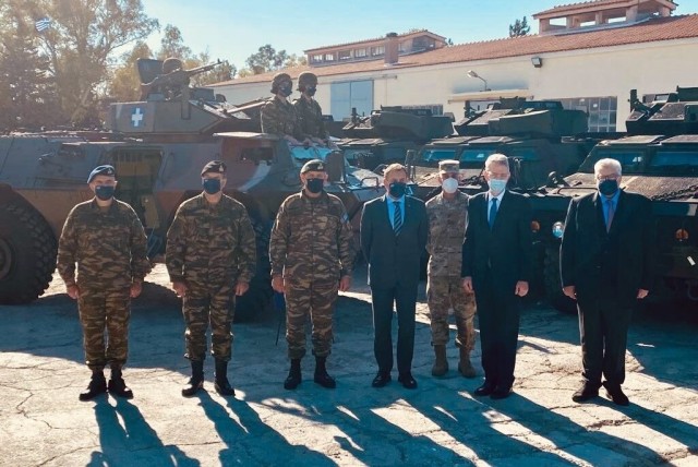 Greek and U.S. military personnel, along with Greece Minister of Defense Nikos Panagiotopoulos and U.S. Ambassador Geoffrey Pyatt, participate in a Dec. 1, 2021 ceremony in Athens. The event marked the delivery of the first of 1,200 M117 Guardian Armored Safety Vehicles being transferred from the U.S. to the Hellenic army via the U.S. Army Foreign Military Sales program.   