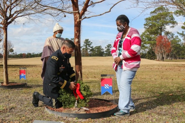 Maj. Gen. Antonio Aguto, commanding general of the 3rd Infantry Division, secures a wreath at the Wreaths for Warriors Walk on Fort Stewart, Georgia, Dec. 19, 2020, for the tree dedicated to Sgt. 1st Class Alwyn Cashe, while Cashe’s sisters,...