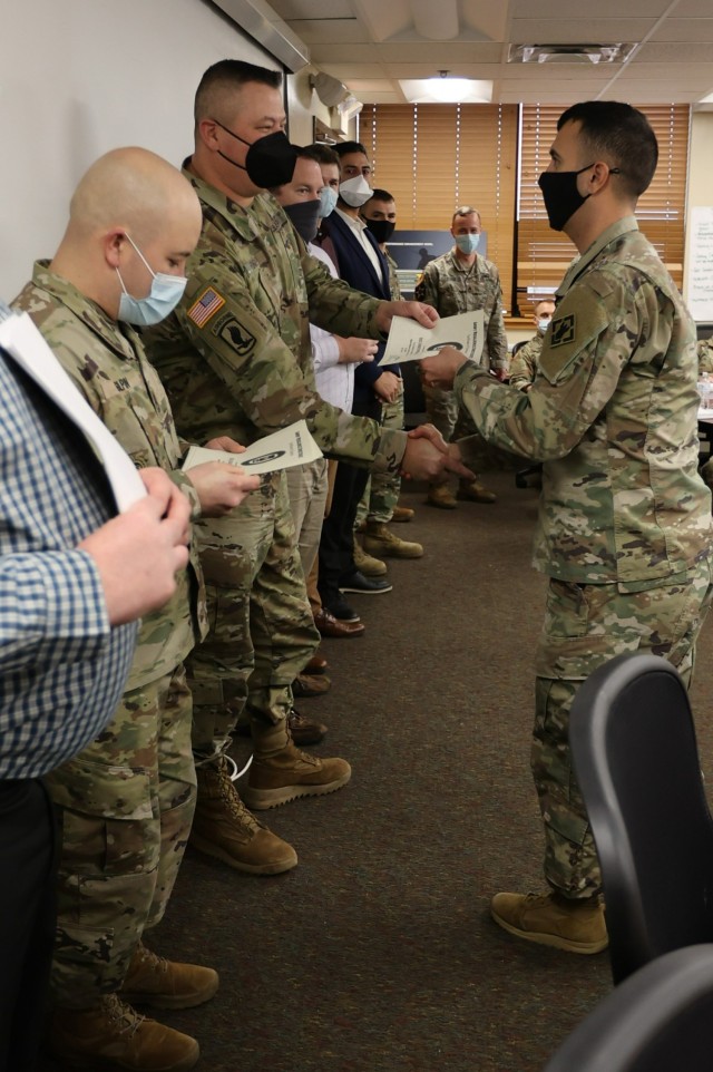 A graduate of the Master Resiliency Course shakes hands with Fort Knox Garrison Command Sgt. Maj. William Fogle Feb. 11, 2022 as he accepts his certificate of completion at the Ready and Resiliency Performance Center. 