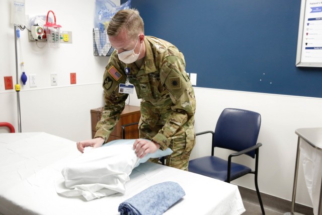 Utah National Guard Sgt. Bracken McKinlay changes sheets and cleans a room after a patient is moved out of the emergency room at St. George Regional Hospital. For the first time since the beginning of the pandemic, Utah National Guard members of the COVID-19 Joint Task Force are providing direct hospital support in non-medical roles. (Photo by Ileen Kennedy)