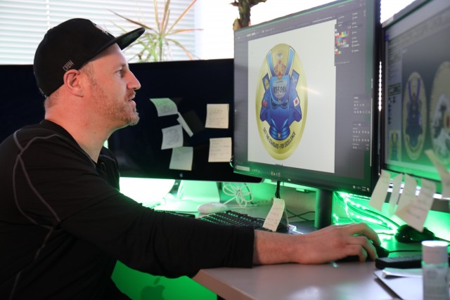 Derek Mayhew, a graphic artist for U.S. Army Garrison Japan's Visual Information Division at Camp Zama, looks at a design he created that was chosen for the new garrison leadership's coin Feb. 3, 2022.