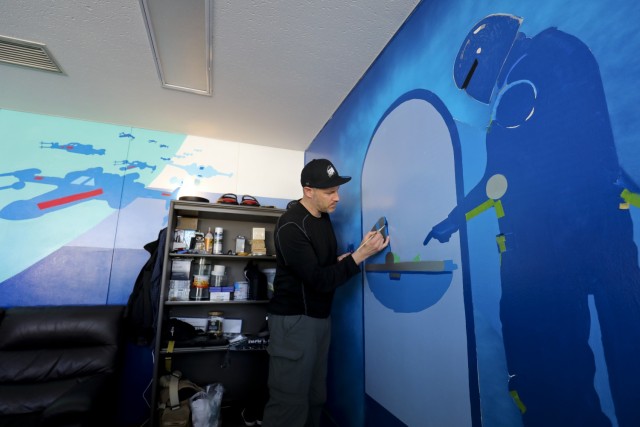 Derek Mayhew, a graphic artist for U.S. Army Garrison Japan's Visual Information Division at Camp Zama, touches up a "Star Wars" painting that he created in his office Feb. 3, 2022. Mayhew recently won a contest to create the...