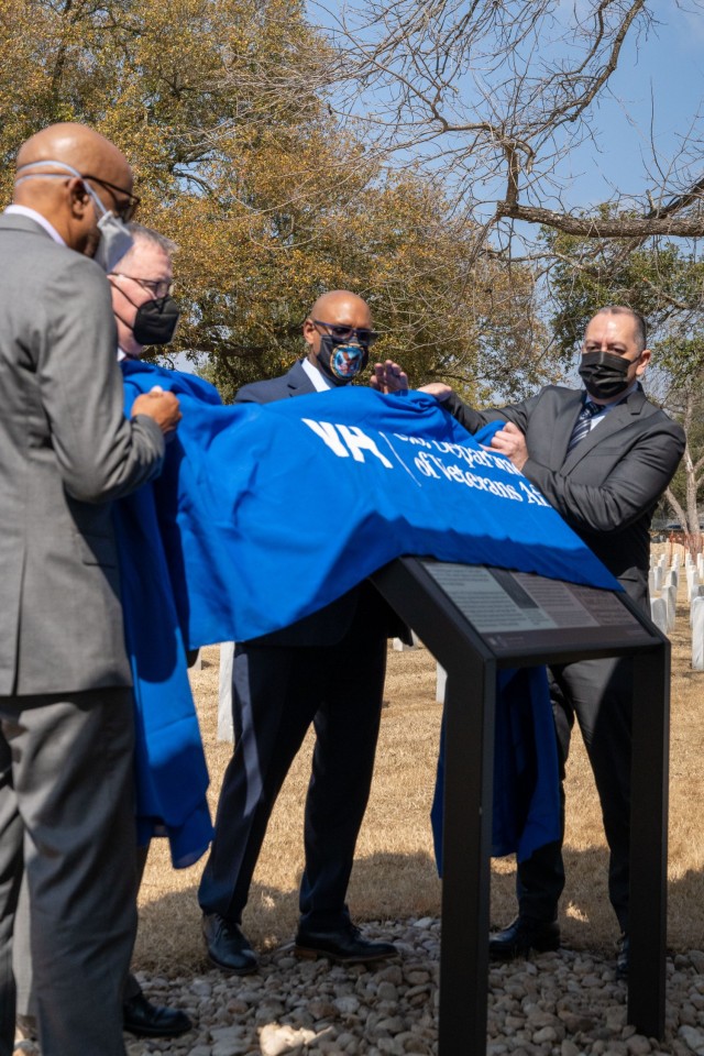 From right to left) Hon. Gabe Camarillo, the Under Secretary of the Army, Donald Remy, Department of Veteran Affairs Deputy Secretary, Matt Quinn, the Under Secretary of Veterans Affairs for Memorial Affairs, and Jason Holt, descendent of Private 1st Class T.C. Hawkins, reveal the interpretative marker during an unveiling ceremony, held at the Fort Sam Houston National Cemetery, San Antonio, Texas, Feb. 22, 2022. During the ceremony, Camarillo acknowledged the history and sacrifice of the Soldiers from the 24th Infantry Regiment and emphasized the marker unveiling is meant to create a broader understanding of what took place in 1917. (U.S. Army Photo by Bethany Huff)