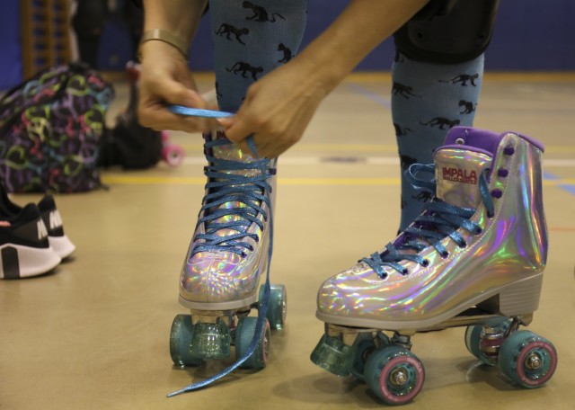A skater tightens up her skates during a roller derby practice for the Zama Killer Katanas at Arnn Elementary School, Sagamihara Family Housing Area, Japan, Feb. 22, 2022.