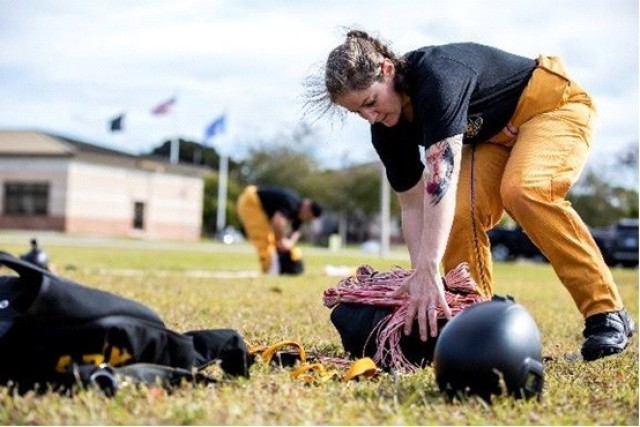 Master Sgt. Jennifer Davidson, Golden Knights demonstration team member, packs her parachute after completing a jump in Homestead, Florida, Feb. 1, 2022.  The Golden Knights are a team of parachutists who serve as U.S. Army ambassadors to the American public. (U.S. Army Reserve photo by Staff Sgt. Alan Graves)