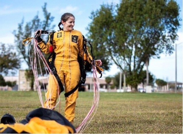 Master Sgt. Jennifer Davidson, Golden Knights demonstration team member, removes her parachute after completing a jump in Homestead, Florida, Feb. 1, 2022.  The Golden Knights are a team of parachutists who serve as U.S. Army ambassadors to the American public. (U.S. Army Reserve photo by Staff Sgt. Alan Graves)