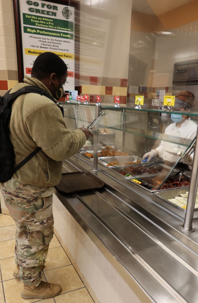 Soldiers wait in line to fill their trays at the Black History Month meal at Cantigny Dining Facility Feb. 28, 2022.