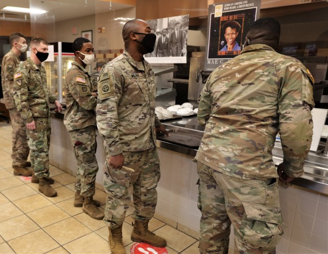 Soldiers wait in line to fill their trays at the Black History Month meal at Cantigny Dining Facility Feb. 28, 2022.