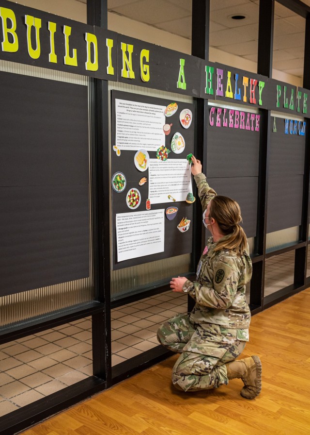 1st Lt. Brittany Powers, outpatient dietitian at the General Leonard Wood Army Community Hospitals Nutrition Care Division, updates the GLWACH Dining Facility’s public information board with healthier eating options from around the world in support of National Nutrition Month – observed annually each March. The hospital dining facility menu is created by GLWACH dieticians to include a wide variety of healthier options, including a daily meatless entre during lunch, along with a wide variety of salads, wraps and other healthier choices. The dining facility is open from 6 to 9 a.m. and 11 a.m. to 6 p.m. Monday through Friday. 