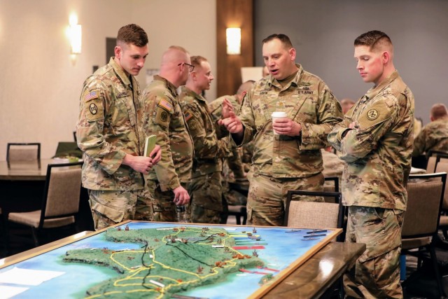 U.S. Army Capt. Nicholas Charnley, Maj. Dermot Gavin, and Maj. Jared Kausner, assigned to the 27th Infantry Brigade Combat Team, New York Army National Guard, discuss the theoretical application of multidomain operations in a modern-day version of the Battle of Saipan in World War II during a leaders workshop in Syracuse, New York, Feb. 26, 2022. The workshop served to prepare the 27th IBCT&#39;s senior leaders for upcoming deployments and development of their future forces. (U.S. National Guard Photo by Maj. Avery Schneider)