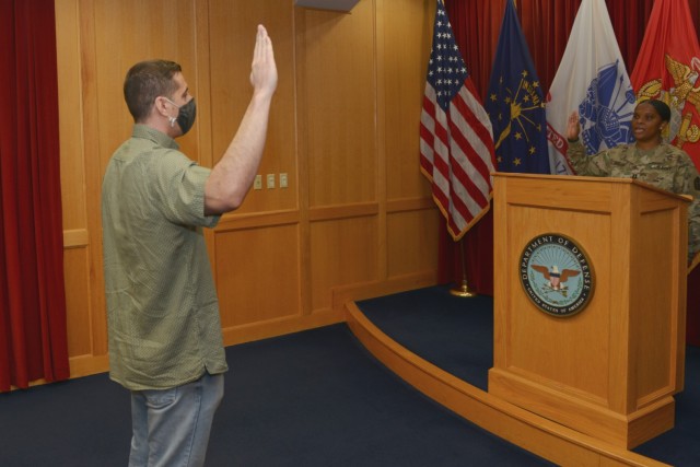 Recruit Mohammad Zaki Ahmadi swears into the Indiana National Guard as U.S. Army Capt. Aissata Diallo administers the oath of enlistment in Indianapolis March 3, 2022. Ahmadi was one of approximately 7,000 Afghan evacuees who filtered through Camp...