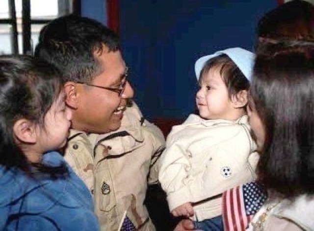 A young AnnaMarie Popoca, far left, can be seen with her father during a homecoming ceremony. Popoca is currently a specialist and transportation management coordinator assigned to 623rd Movement Control Team, 35th Combat Sustainment Support Battalion. Popoca, 22, chose to join the Army and follow in the footsteps of her father, who served more than 20 years as a motor transport operator.