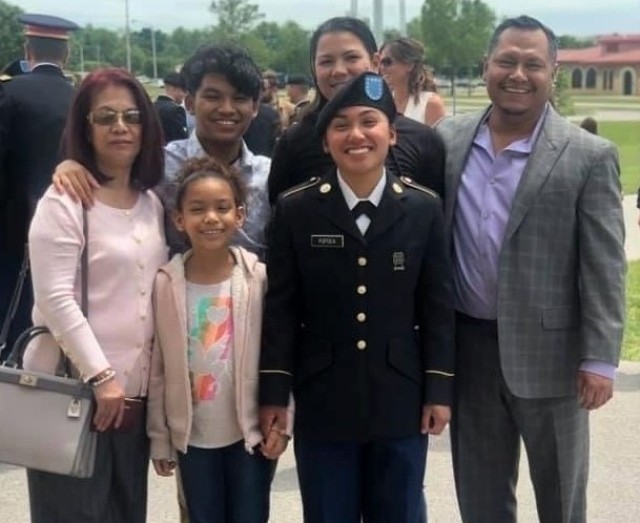 AnnaMarie Popoca, front center, takes a photo with her family after she graduated from basic combat training. Popoca is currently a specialist and transportation management coordinator assigned to 623rd Movement Control Team, 35th Combat Sustainment Support Battalion. Popoca, 22, chose to join the Army and follow in the footsteps of her father, pictured far right, who served more than 20 years as a motor transport operator.