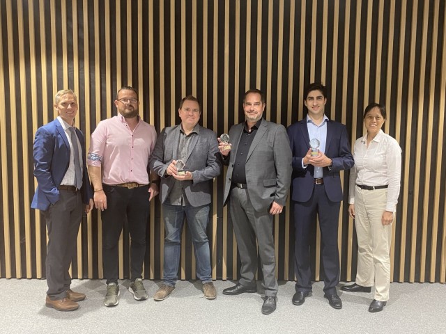 Nathan Anderson, DEVCOM Atlantic technical director (left), and Col. Jenny Stacy, DEVCOM Atlantic director (right), pose with the winners of the xTechGlobal Artificial Intelligence Challenge in September 2021. The next iteration of the competition series, xTechInternational, is currently under way. 
