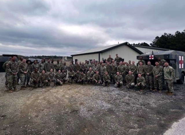 Personnel of the Kenner Army Health Clinic pose after the final day of a medical field training exercise Fort Lee, Virginia. 
