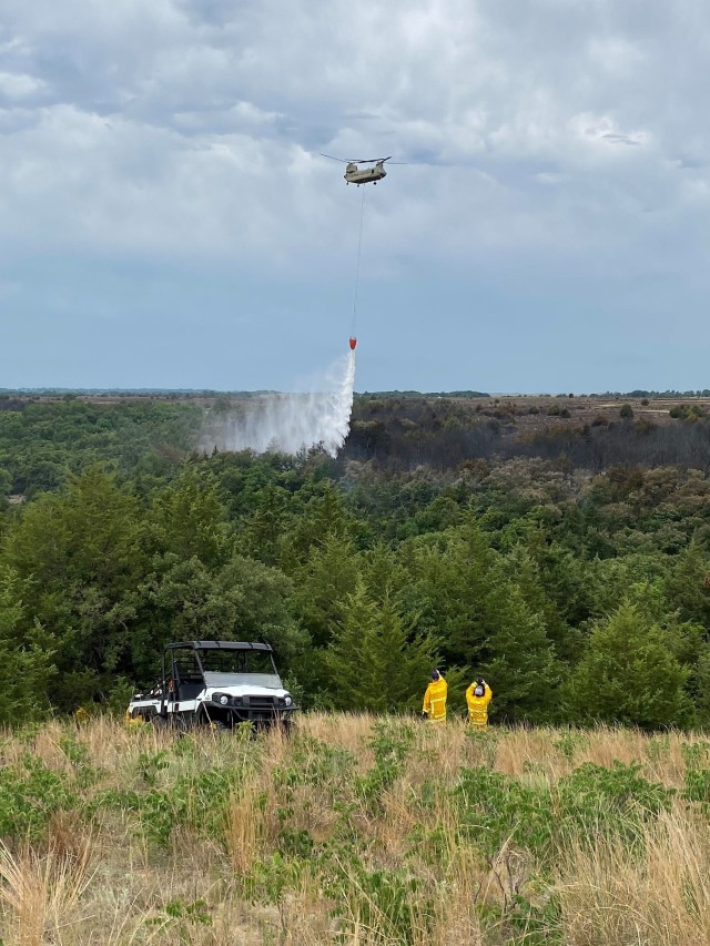 Soldiers flying a Nebraska Army National Guard CH-47 Chinook helicopter above the Spring Creek division of the Brush Creek fire drop water from their 2,000-gallon bucket June 25, 2021 in Holt County, Nebraska. The Team’s work is integral to not only improving crane habitat, but also deconflicting the NEARNG’s aviation mission from wildlife.