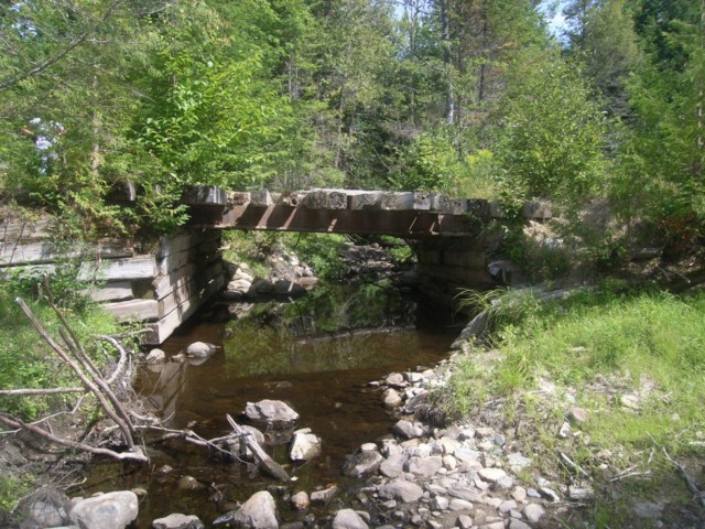 Developing a training site without functional infrastructure was a key challenge for WTS. The existing crossing of East Branch Trout Brook pictured here would not support military vehicles and created a pinch-point for flow that resulted in stream...
