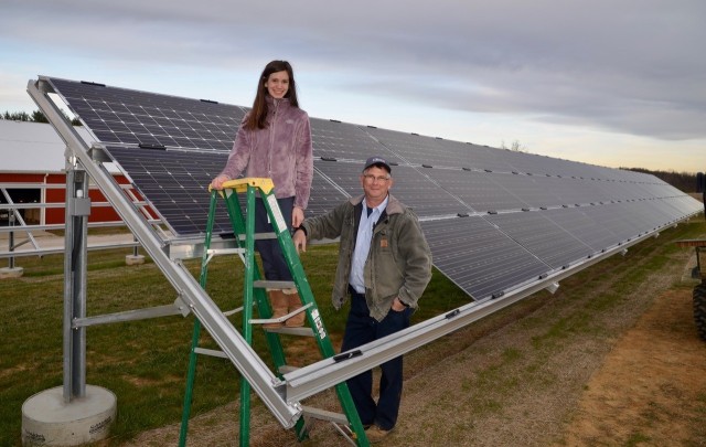 Kentucky farmer Robbie Williams poses with his daughter following the installation of solar panels on their family farm. 