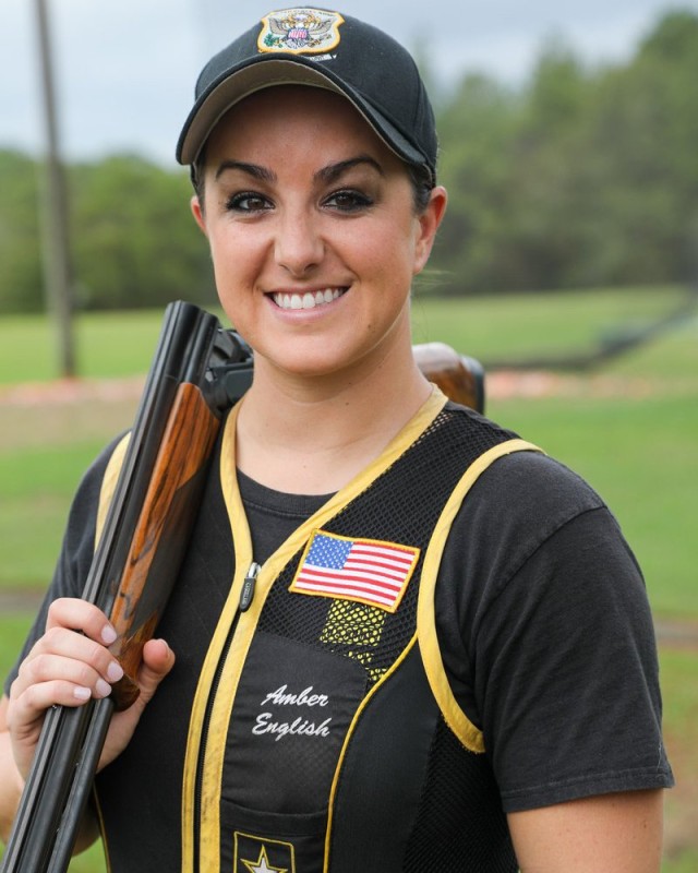 Army 1st Lt. Amber English poses for a photo wielding a shotgun and wearing sport shooting attire.