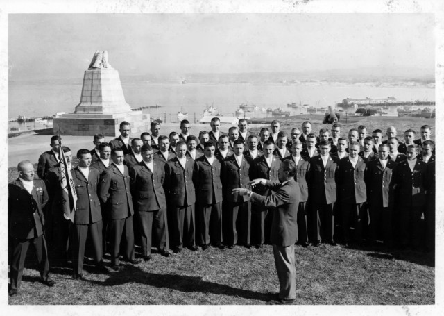 Members of the Defense Language Institute’s Russian Language Soldiers’ Chorus sing in front of the Sloat Monument, former Fort Mervine, Monterey, Calif., 1965. Nicholas Vorobiov, instructor and choir master, directs them.