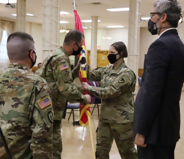 Command Sgt. Maj. Petra Casarez (right) accepts the Joint Munitions Command colors from Brig. Gen. Gavin Gardner (center), JMC commander, as outgoing Command Sgt. Maj. Brian Morrison (left) looks on at a change of responsibility ceremony August 24, 2021.