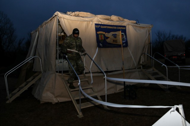 U.S. Army Pfc. Dellshay Williams, a Soldier assigned to the 511th Quartermaster Company, 1st Special Troops Battalion, 1st Sustainment Brigade, 1st Infantry Division, exits the 511 QMC mobile field kitchen with a breakfast provided by his teammates during the early hours of the competition. 