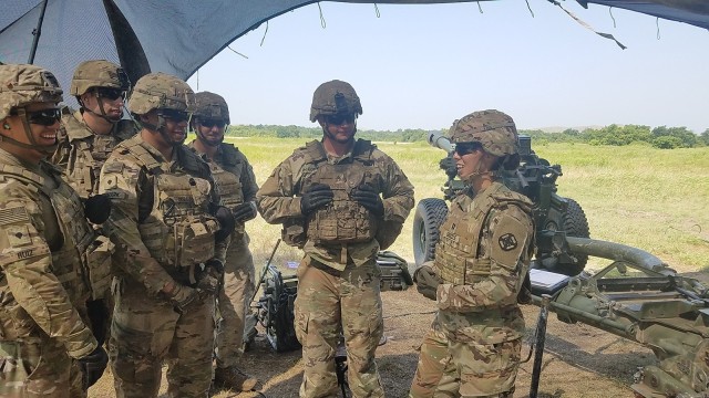 Capt. Catherine Grizzle, A Battery, 2nd Battalion, 2nd Field Artillery commander, right, talks with cannon crew members on June 24, 2021, at a firing point on Fort Sill, Oklahoma. Grizzle, who spoke during a Women&#39;s History panel on March 25, 2022, was one of the first women to be selected as a gunnery instructor at the Army’s Field Artillery School in Lawton, Okla.
