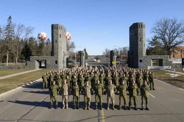  Minnesota National Guard Soldiers and service members from the Norwegian military’s Home Guard in front of the main gate at Camp Ripley, Minnesota, March 26, 2022, after the start of the the 49th Annual Norwegian Exchange. The partnership develops relationships between international allies through training exercises in Minnesota and Norway. (Minnesota National Guard Photo by Sgt. Mahsima Alkamooneh)