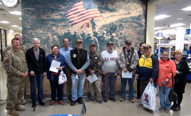 Col Jarrod Moreland, Commander, U.S. Army Garrison-Fort Huachuca, and other leaders pose with  Vietnam Veterans and their families during pinning ceremonies at the Post Exchange on March 29,  National Vietnam War Veterans Day