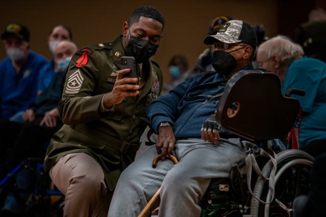 Sgt. Maj. Kenyatta Gaskins, enlisted advisor for Military Personnel Management, Army G-1, shows a  Vietnam veteran photos on his phone during the 50th Vietnam War Commemoration. The commemoration, held at Charlotte Hall Veterans Home in southern Maryland, also honored the more than 1,600 U.S. military and civilian personnel who are still unaccounted for; the Soldiers were considered POW/MIA.