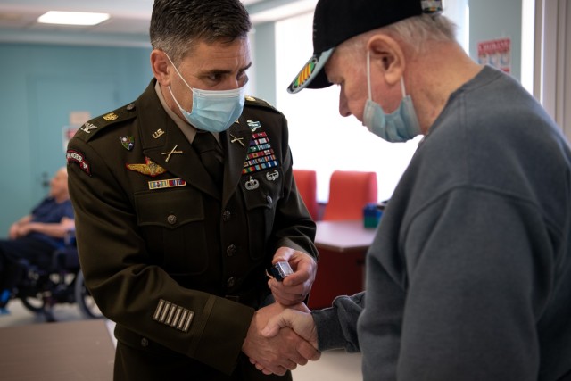 Col. Michael Katona, Deputy Chief of Legislative Liaison, presents a Vietnam veteran with a lapel pin to honor and and recognize him during the 50th Vietnam War Commemoration. The commemoration, held at Charlotte Hall Veterans Home in southern Maryland, also honored the more than 1,600 U.S. military and civilian personnel who are still unaccounted for; the Soldiers were considered POW/MIA.