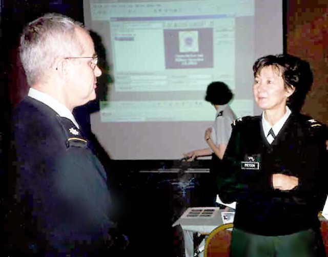 Col. Coral Wong Pietsch, chief judge (Individual Mobilization Augmentee) talks with Lt. Col. Lee Stockdale of the 81st Regional Support Command (left) during the on-site legal training conference co-sponsored by the Army Reserve's 12th Legal...
