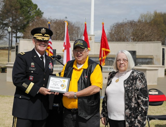 Retired Sgt. Jerry Cox receives an award from the Vietnam Veterans of America Chapter 1067 for his loyalty and support to the chapter. The award was presented by Lt. Gen. Donnie Walker, deputy commanding general of the Army Materiel Command and Redstone Arsenal senior commander, on behalf of Chapter 1067 during the Vietnam Veterans Day Celebration at the Huntsville-Madison County, Ala., Veterans Memorial March 29. 