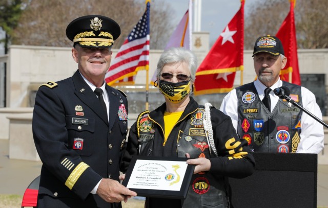 Barbara Langford receives the 2022 Associates Vietnam Veteran of America Member of the Year Award for her support at recording secretary to VVA Chapter 1067. The award was presented by Lt. Gen. Donnie Walker, deputy commanding general of the Army Materiel Command and Redstone Arsenal senior commander, on behalf of Chapter 1067 during the Vietnam Veterans Day Celebration at the Huntsville-Madison County, Ala., Veterans Memorial March 29. In the background is retired Command Sgt. Maj. John Perry, who served as a master of ceremonies.
