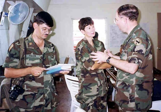 Col. Coral Wong Pietsch (center), senior legal officer for the BALIKATAN 95 exercise, gets a briefing from Lt. Col. Dave Lowry, officer in charge of the U.S.-Philippine command post exercise in November 1995. On the left is Maj. Randy Pullen,...